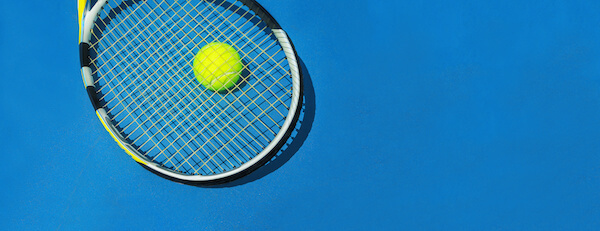 Tennisschläger und Ball auf Hartplatz